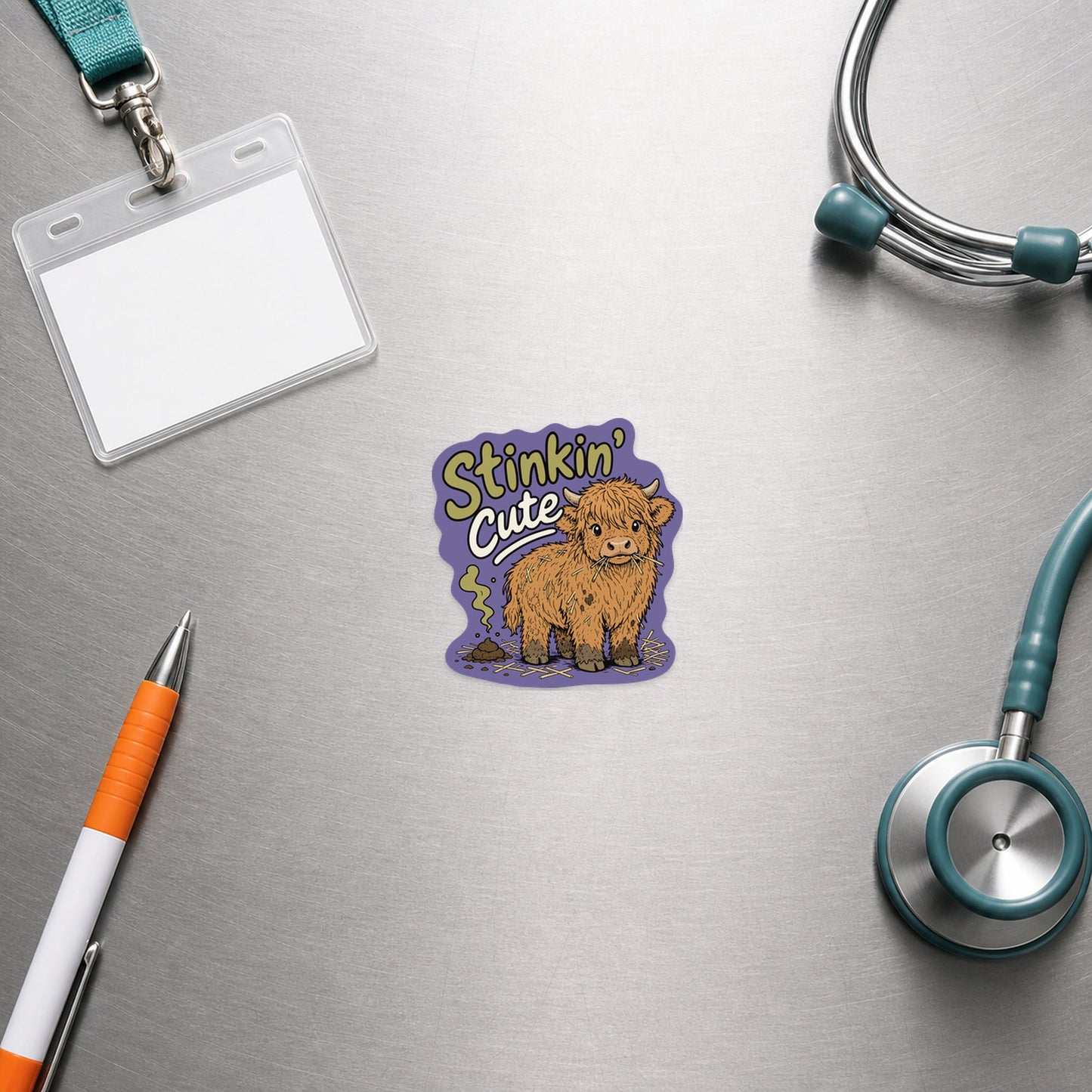 🐮 Stinkin' Cute Highland Cow – Funny Vet Sticker shown in a veterinary clinic flat lay
