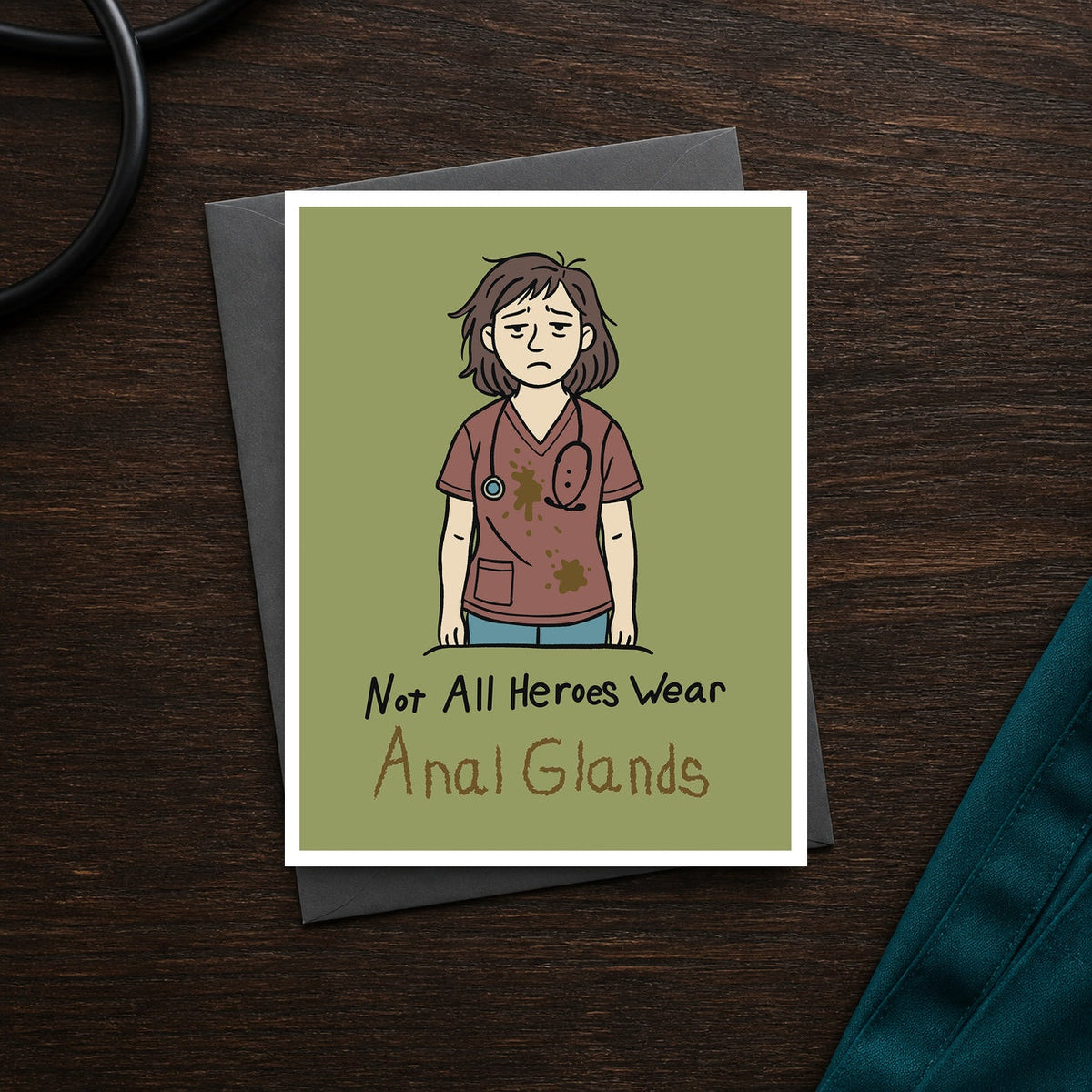 Not All Heroes Wear Anal Glands A2 veterinary notecard front on a dark clinic desk