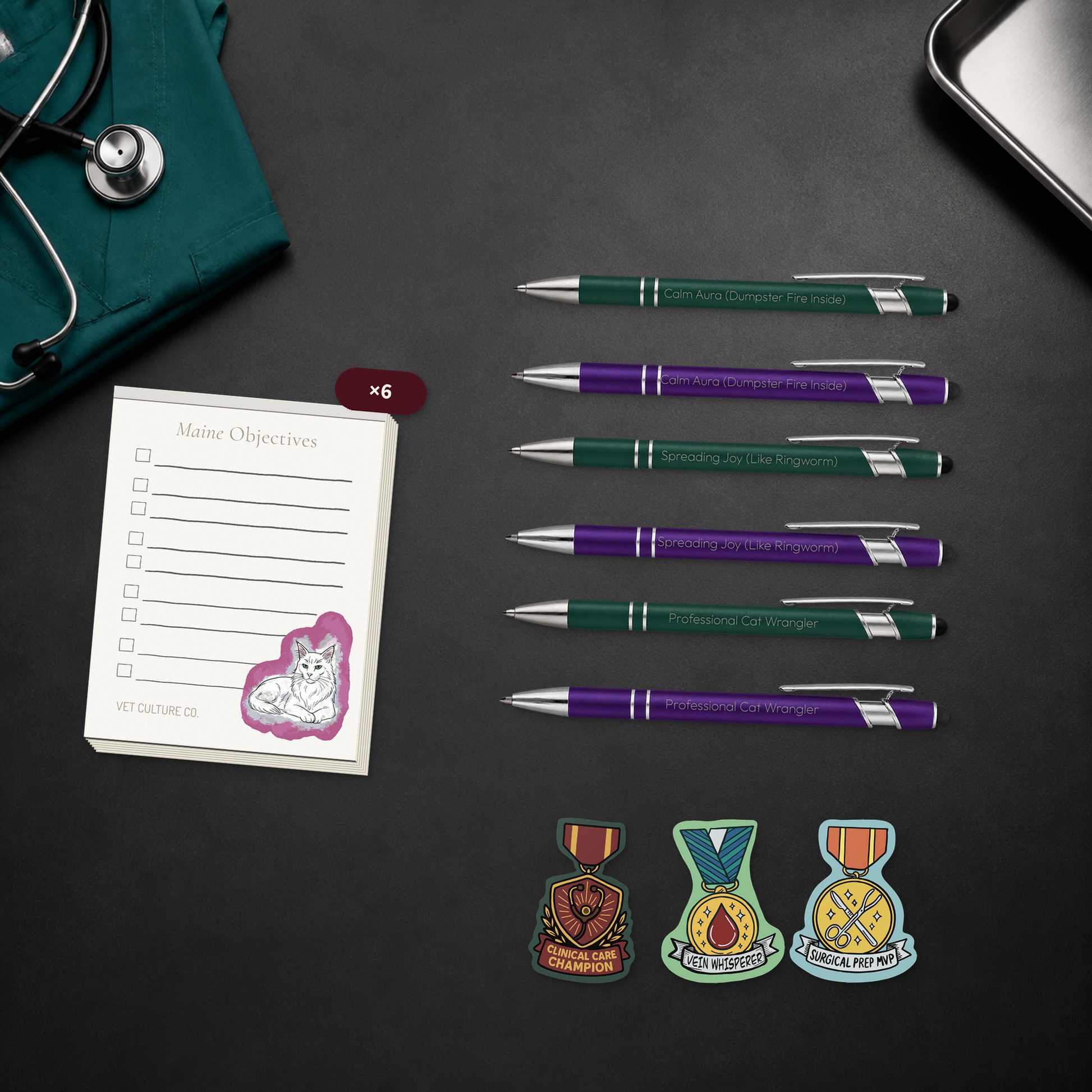 Desk Drop Six-Pack veterinary team bundle with six notepads, six engraved pens, and six award stickers, shown in a close material-detail scene for veterinary professionals
