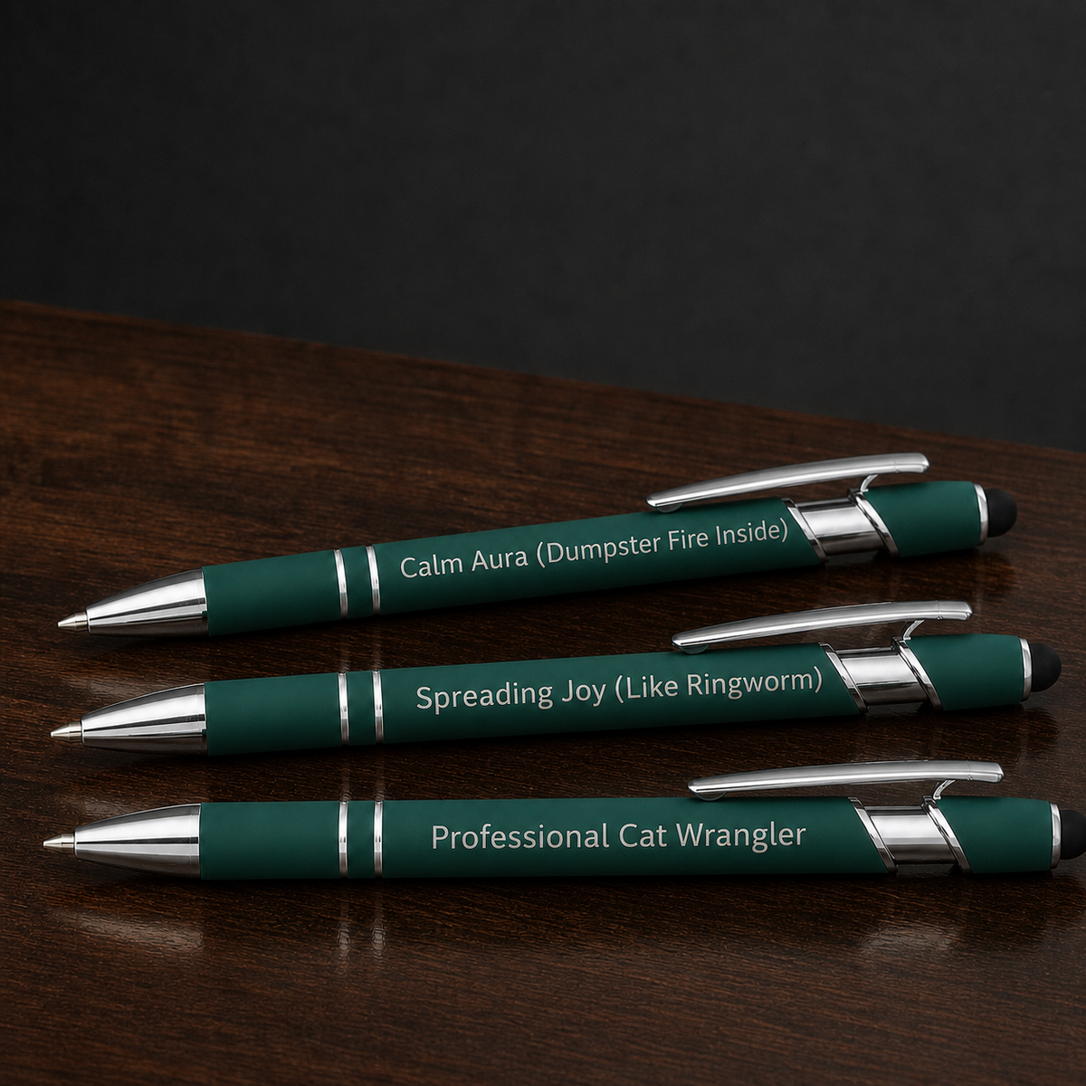 Close view of three dark green veterinary pens with silver laser engraving and stainless steel hardware