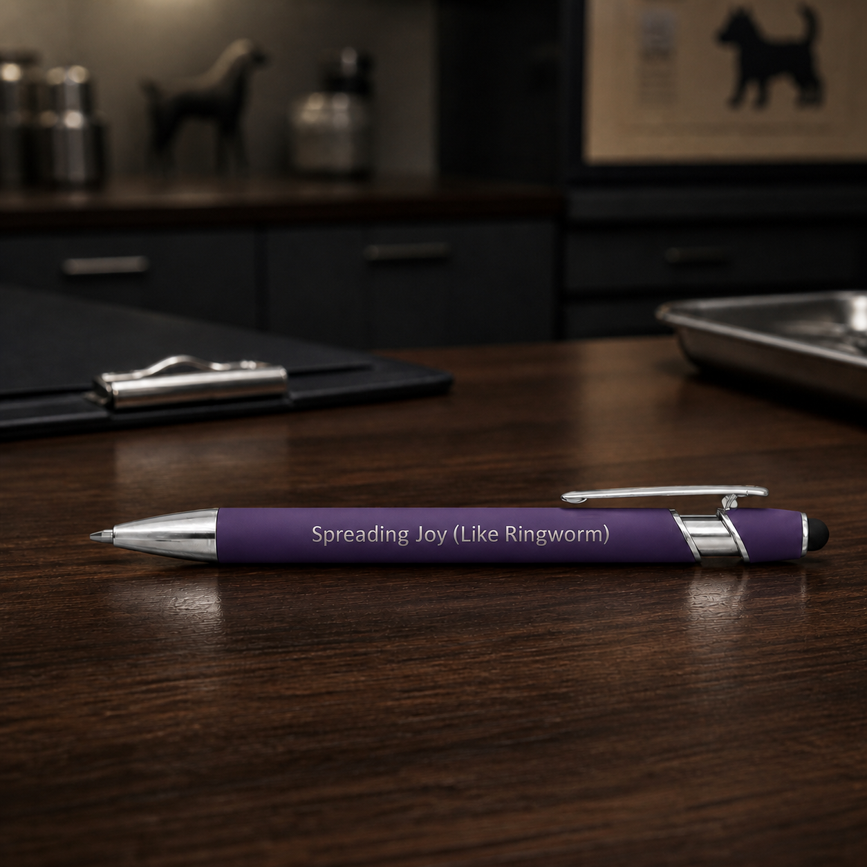 Purple Spreading Joy Like Ringworm laser-engraved veterinary pen with stainless steel hardware on a dark clinic desk