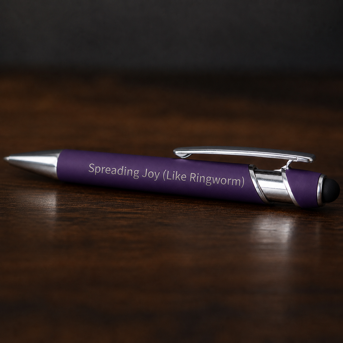 Close view of a purple Spreading Joy Like Ringworm pen with silver engraving and stainless steel hardware